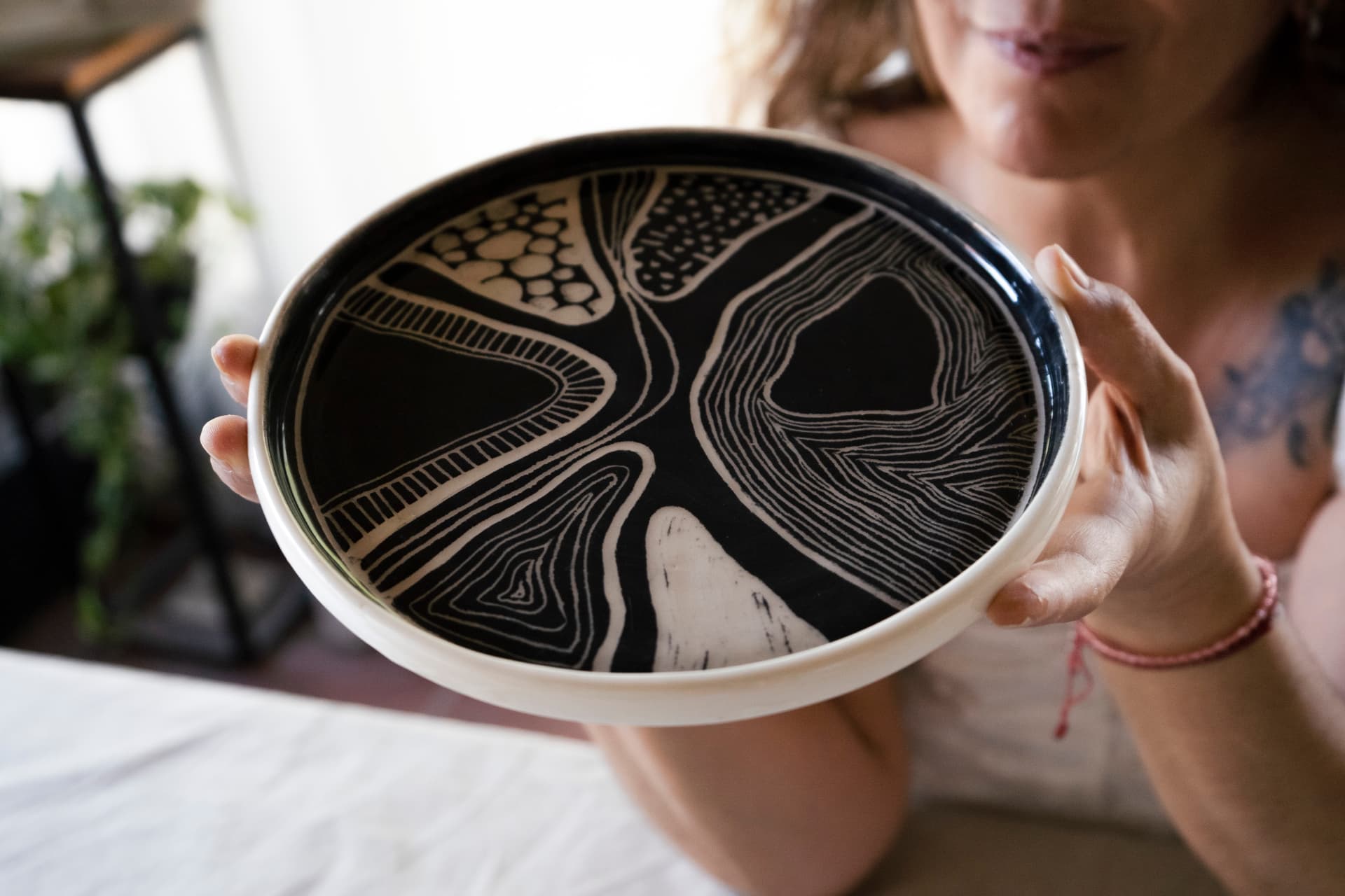 Plato de cerámica artesanal negro con esgrafiado de líneas y texturas hecho a mano