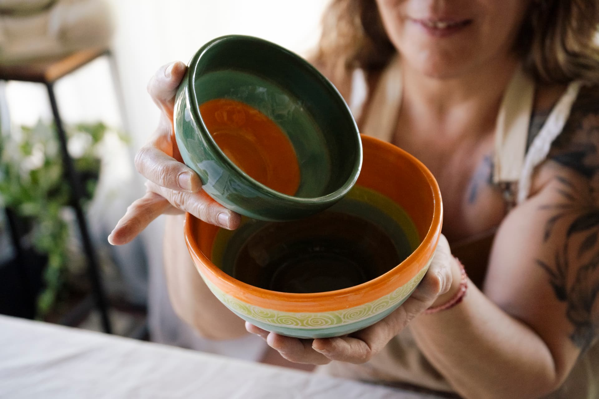 Bowls verdes y naranjas sostenidos en el taller