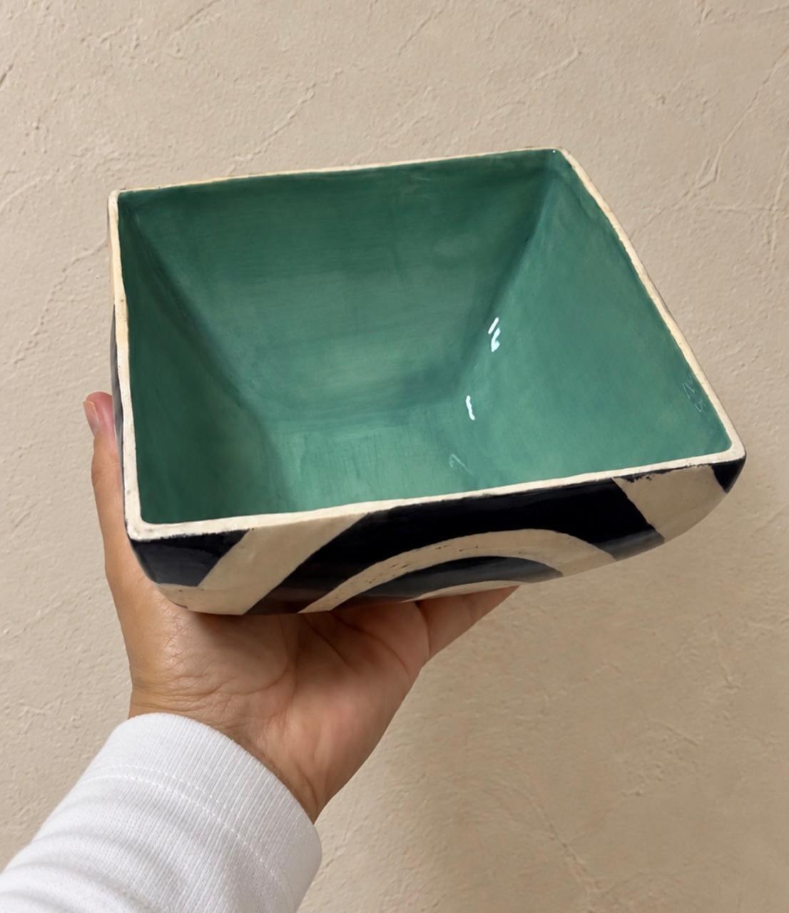 Interior verde de un bowl cuadrado de cerámica UGA con trazos en blanco y negro